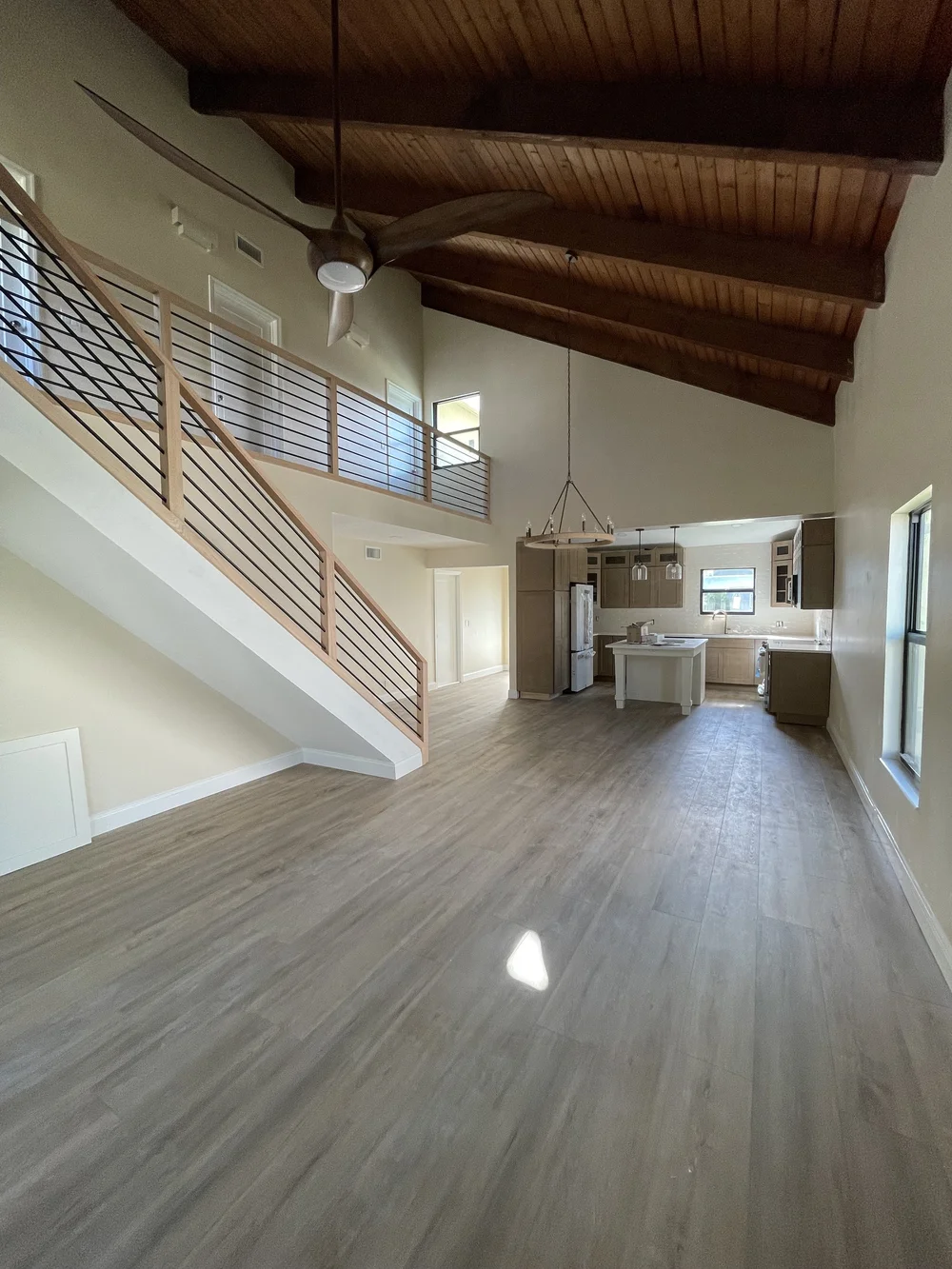 Complete home remodeling project in Boca Raton featuring open-concept living with exposed beams and modern staircase by GPS Remodeling