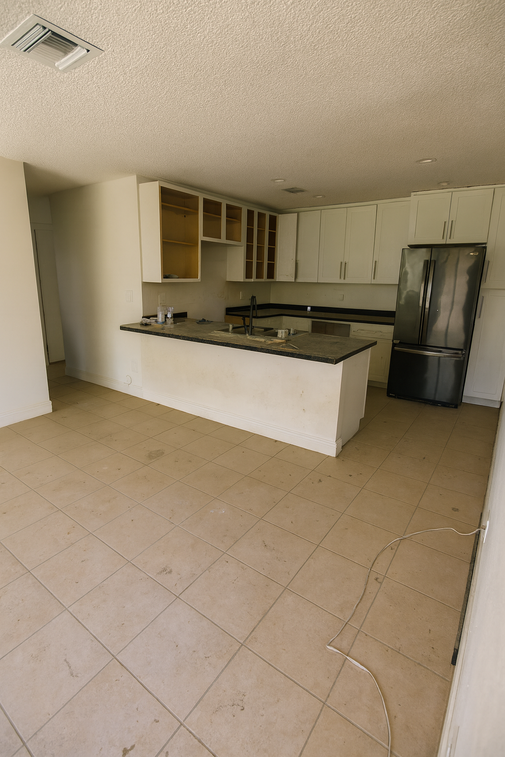 Kitchen before remodeling - outdated cabinets, dark countertops, and unfinished construction